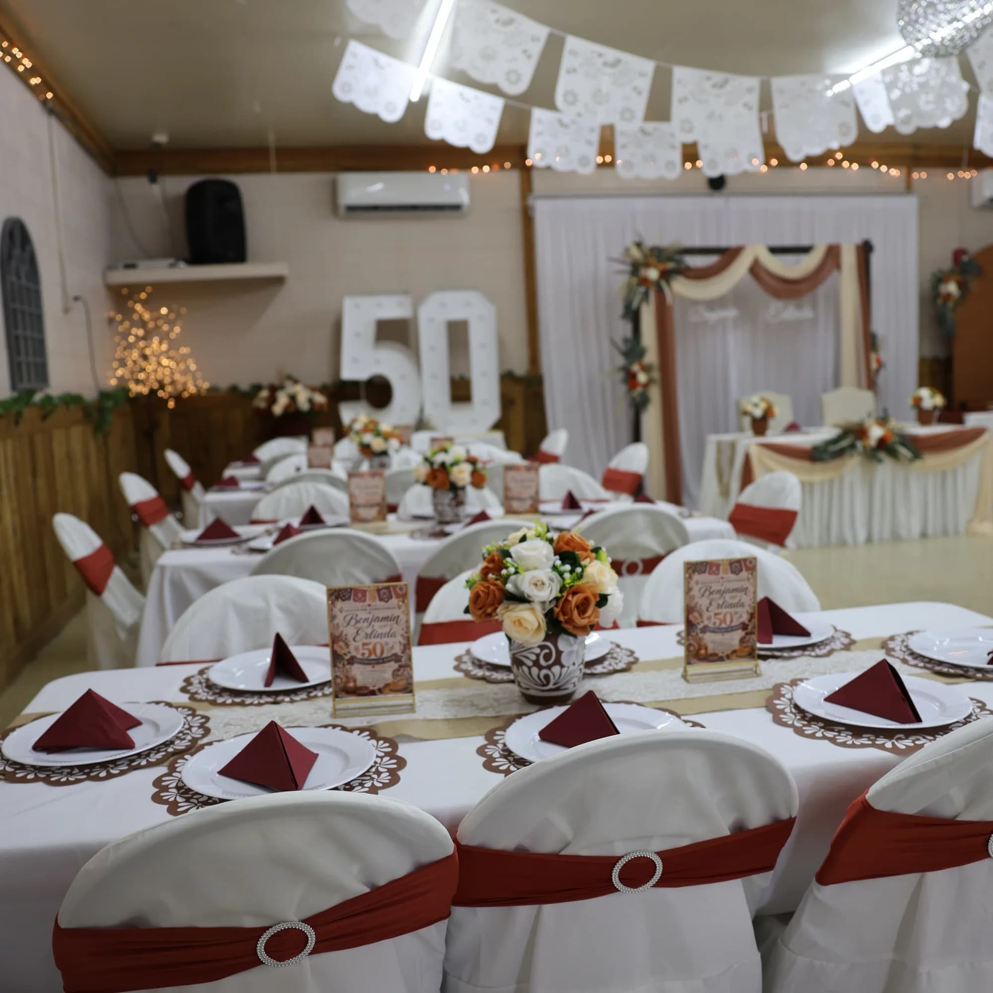 Reception table with a custom 50th anniversary menu card at El Rancho Event Center