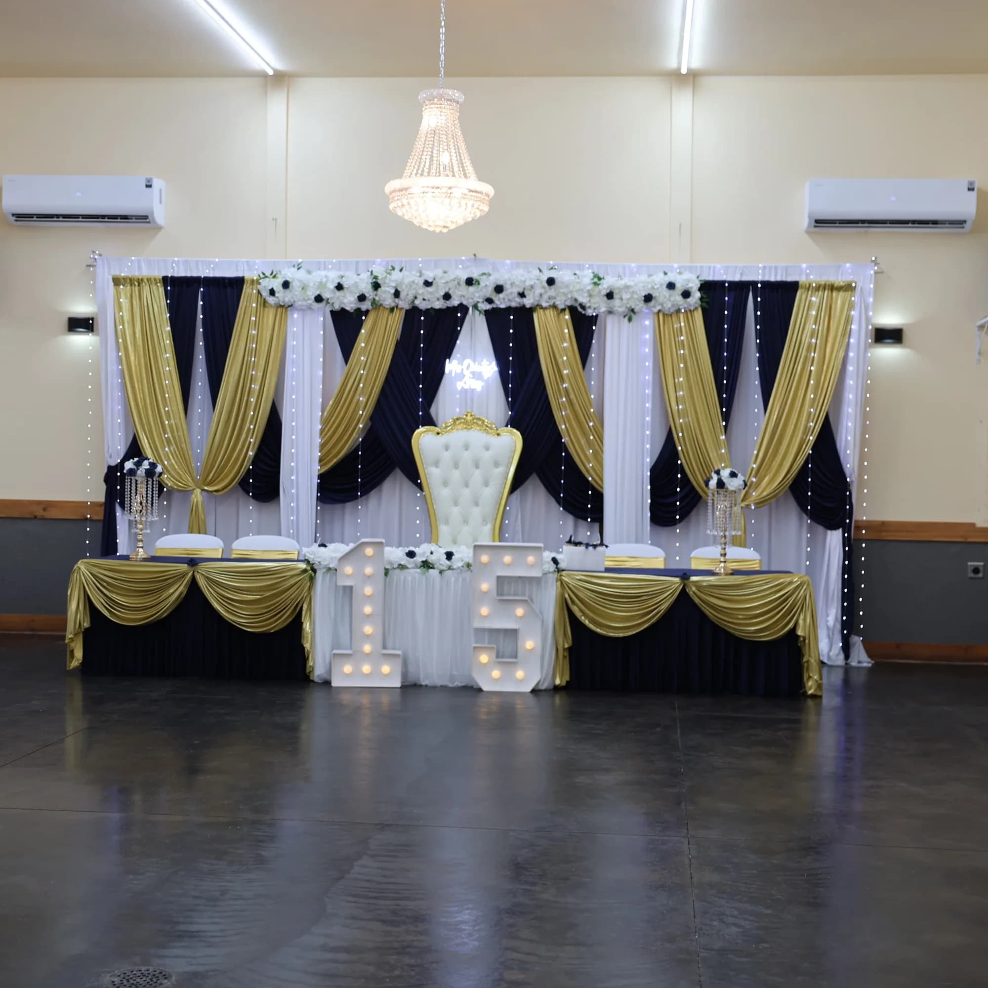 Navy and gold stage backdrop for a quinceañera at El Rancho Event Center